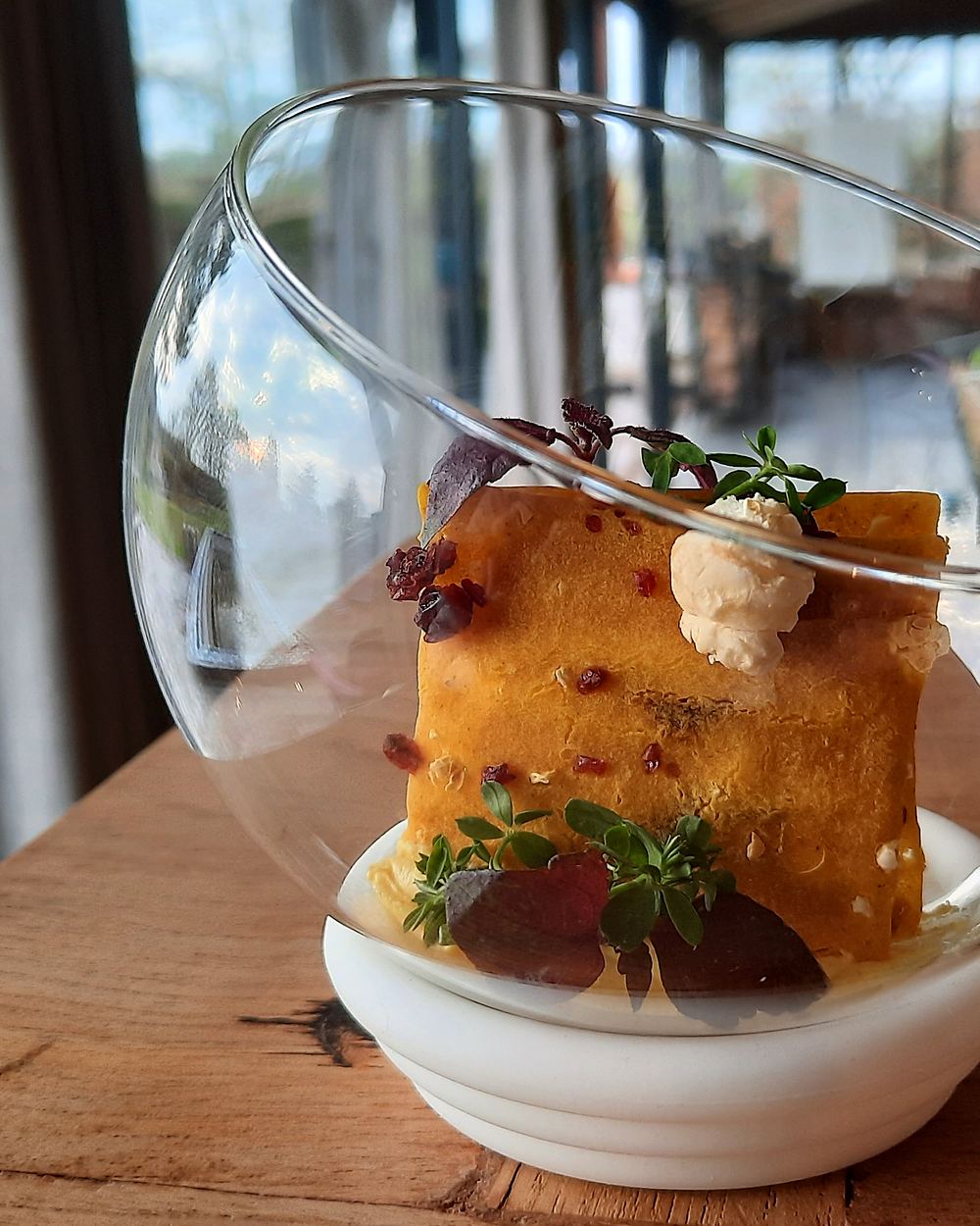 Dessert in een glazen schaal, opgemaakt met kruiden en bessen