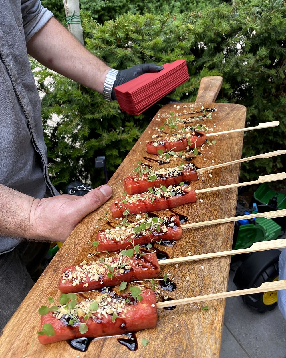 Spiesjes met sesam en kruiden op een lange houten plank